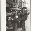 Men watching World Series baseball scores on main street, Montrose, Colorado