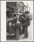 Men watching World Series baseball scores on main street, Montrose, Colorado
