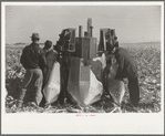 Farmers examine a two-row mounted corn picker, mechanical cornhusking contest, Hardin County, Iowa