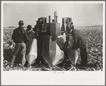 Farmers examine a two-row mounted corn picker, mechanical cornhusking contest, Hardin County, Iowa