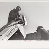 Farmer adjusts corn picker at mechanical cornhusking contest, Hardin County, Iowa