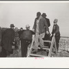 Farmers coming over a stile, at mechanical cornhusking contest, Hardin County, Iowa