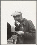 Farmer eats hamburger at cornhusking contest, Marshall County, Iowa