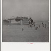 Farmer and sons walking in the face of a dust storm. Cimarron County, Oklahoma