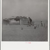 Farmer and sons walking in the face of a dust storm. Cimarron County, Oklahoma