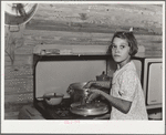 While father and mother are both at work in the citrus packing plant this little girl keeps house. Winterhaven, Florida