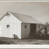 Mr. Cherser unloading some of his farming implements at the barn on his new homestead. Greenwood, [Jefferson County?,] Alabama