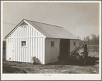Mr. Cherser unloading some of his farming implements at the barn on his new homestead. Greenwood, [Jefferson County?,] Alabama