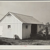 Mr. Cherser unloading some of his farming implements at the barn on his new homestead. Greenwood, [Jefferson County?,] Alabama
