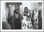 Fashion designer Patrick Kelly assisting a model who is wearing one of his dress designs