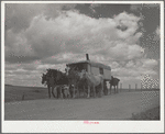A modern covered wagon family going west for work. Pennington County, South Dakota