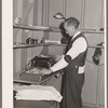 Putting out newspaper. Tulare migrant camp. Visalia, California
