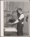 Putting out newspaper. Tulare migrant camp. Visalia, California