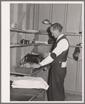 Putting out newspaper. Tulare migrant camp. Visalia, California