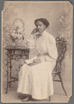 Studio portrait of a young woman in white, seated with book in lap: Edith Dix