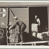 Farmers unload new potato sacks brought by growers' co-operative. Monte Vista, Colorado