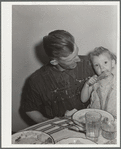 Thomas Beede and small daughter at the dinner table in their home. Western Slope Farms, Colorado