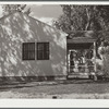 Mrs. Carl Higgins, wife of tenant purchaser, and son on porch of home. Mesa County, Colorado