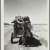 Drought refugees from South Dakota on highway making sure that nothing falls off the trailer to the Pacific Coast. Montana