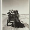 Drought refugees from South Dakota on highway making sure that nothing falls off the trailer to the Pacific Coast. Montana