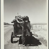 Drought refugees from South Dakota on highway making sure that nothing falls off the trailer to the Pacific Coast. Montana