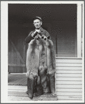 Perley Mosley with three pelts from foxes he trapped. Eden Mills, Vermont