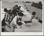 Older boys scrub nursery school cots on Saturday morning. Robstown camp, Texas