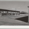 Row shelter with community building in background. Robstown FSA (Farm Security Administration) camp, Texas