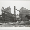 During an abundant harvest many corn cribs are filled while they are still under construction. Grundy County, Iowa