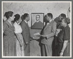 Group portrait of Dunbar Tenants League gathered around portrait of writer Paul Laurence Dunbar
