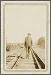Portrait of Arthur Schomburg standing on railroad track