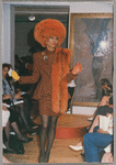 Model in Patrick Kelly Paris fashion show wearing large orange fur hat and scarf