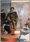 Model in Patrick Kelly Paris fashion show wearing fur coat, red pants, and drop earrings
