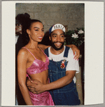 Fashion designer Patrick Kelly (right), wearing overalls, and unidentified woman pose at a fashion event in Paris