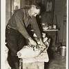 Frank Walker, farmer cutting meat in his farm home near Dalton, New York