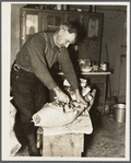 Frank Walker, farmer cutting meat in his farm home near Dalton, New York