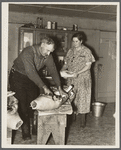 Frank Walker, farmer cutting meat in his farm home near Dalton, New York
