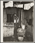 Steel worker in kitchen of slum apartment. Midland, Pennsylvania