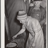 Wife of evicted sharecropper in tent along highway cooking beans obtained from surplus commodities. New Madrid County, Missouri