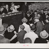 Buyers at auction of fruit and vegetables at produce market. Pier 29, New York City