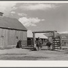 Ranchers riding through corral gate. Quarter Circle 'U' Ranch, Montana