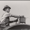 Hired hand tunes in radio on tractor while cutting hay. Kimberley farm, Jasper County, Iowa