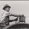 Hired hand tunes in radio on tractor while cutting hay. Kimberley farm, Jasper County, Iowa