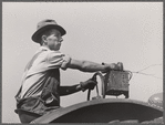 Hired hand tunes in radio on tractor while cutting hay. Kimberley farm, Jasper County, Iowa