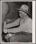Andy Bahain, FSA (Farm Security Administration) borrower milking a cow on his farm near Kersey, Colorado