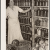 Wife of resettlement borrower, San Luis Valley Farms, Colorado, displaying fruit and vegetables preserved for winter use