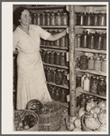 Wife of resettlement borrower, San Luis Valley Farms, Colorado, displaying fruit and vegetables preserved for winter use