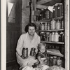 Mrs. Calvin Brown, wife of FSA (Farm Security Administration) borrower, and grandson with fruit preserved on their farm. Weld County, Colorado