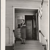 Lois Slinker, teacher of the one room school house. rings bell to end recess period. Grundy County, Iowa