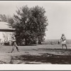 Teacher supervises ball game during recess period. Grundy County, Iowa